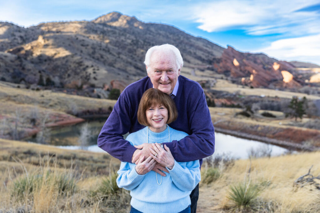 Husband and wife in red rocks.  A couple celebrates their 50 year anniversary in Colorado.  Littleton extended family photographer.
