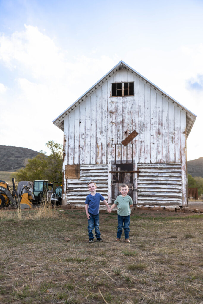 Littleton family photographer at Hildebrand Ranch with a barn at sunset