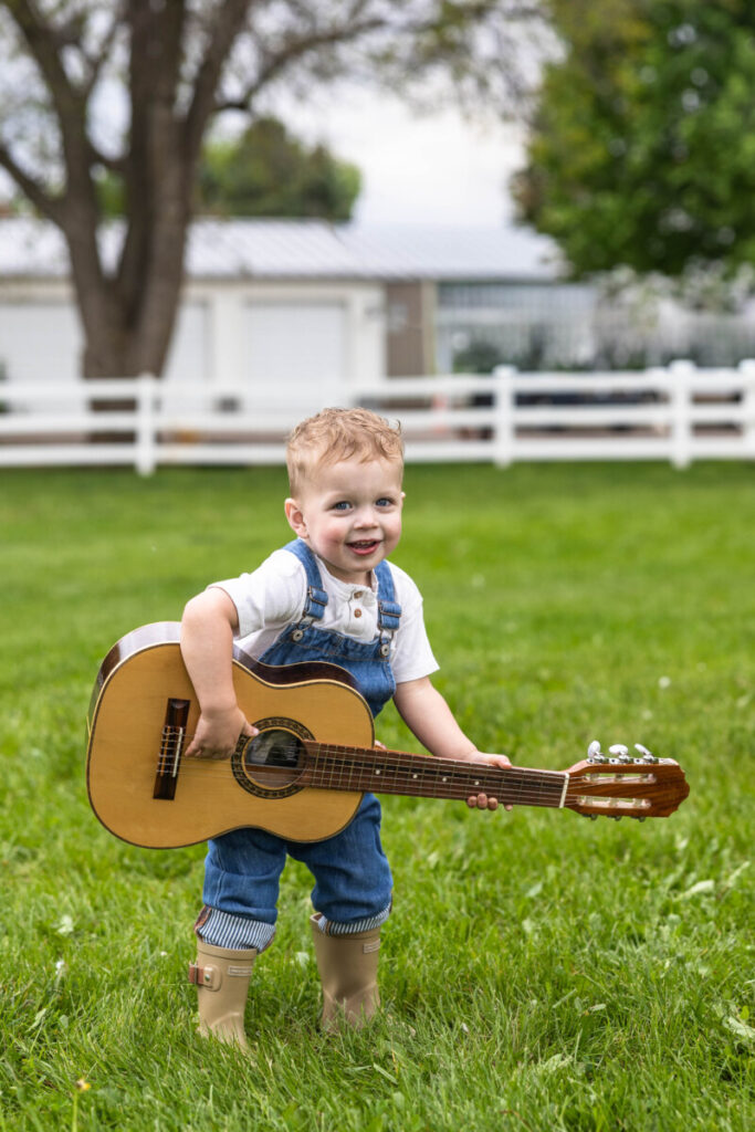 Colorado family and child photographer in Colorado of a little boy with a guitar