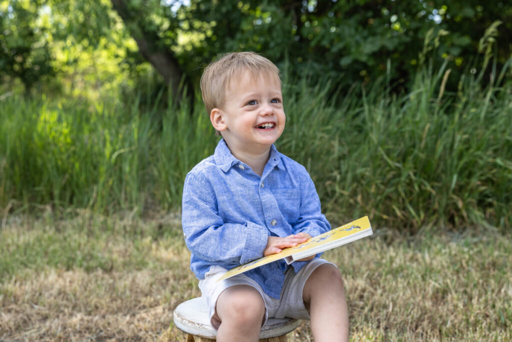 Toddler boy reading books in Littleton for family photo session