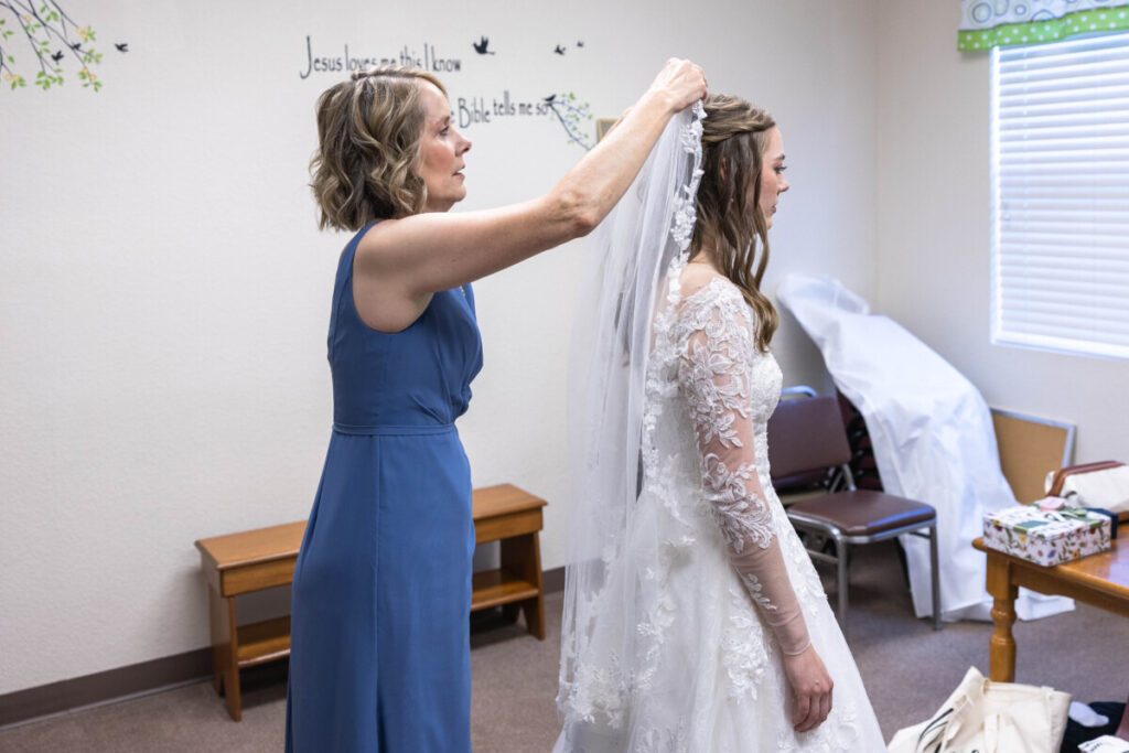 Bride and mother getting ready with bridal veil