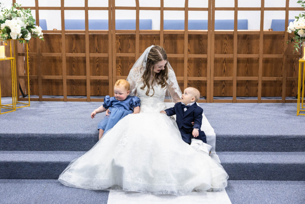 Bride with flower girl and ring bearer babies at church before wedding