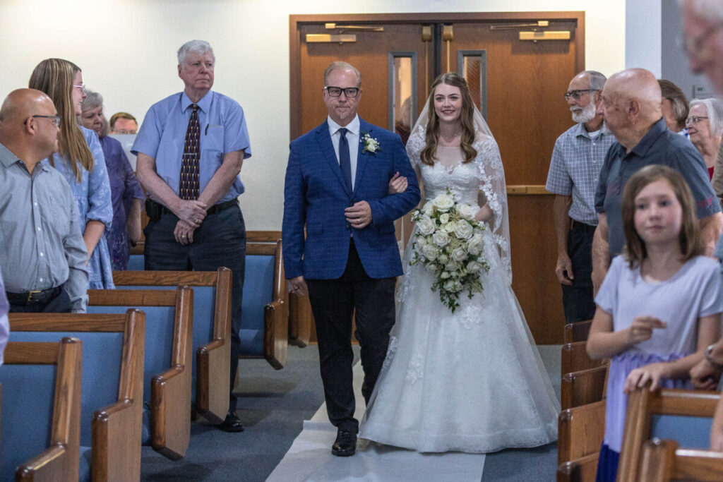 Bride walking down the aisle to her groom at wedding
