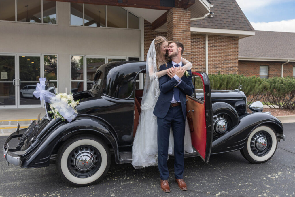 Bride and groom with vintage car in Colorado