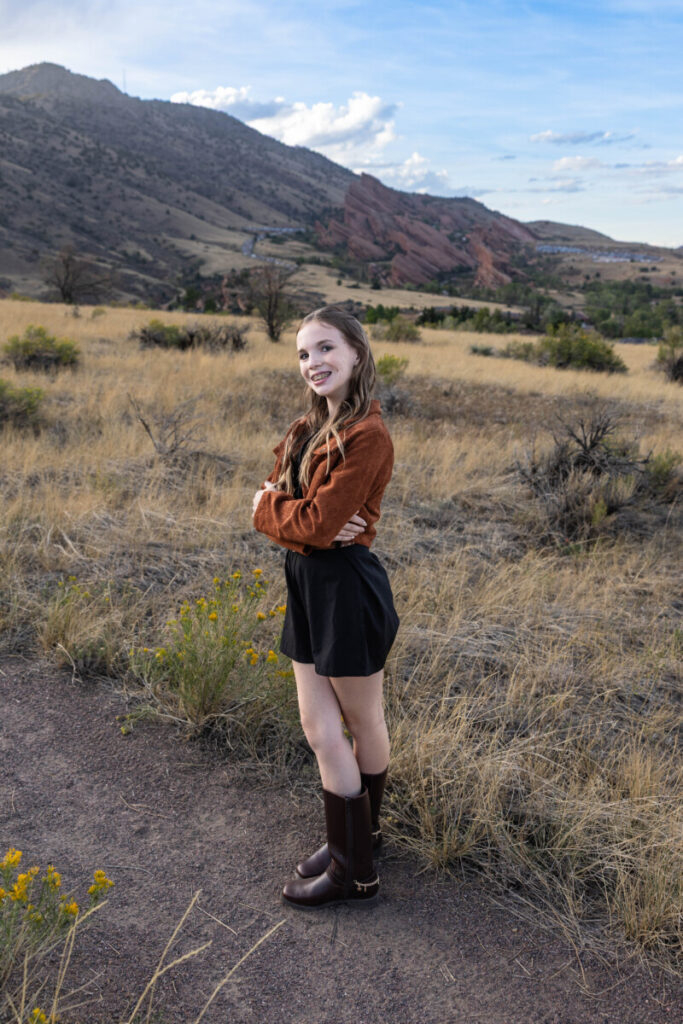 Colorado family photographer with red rocks and a teen at sunset