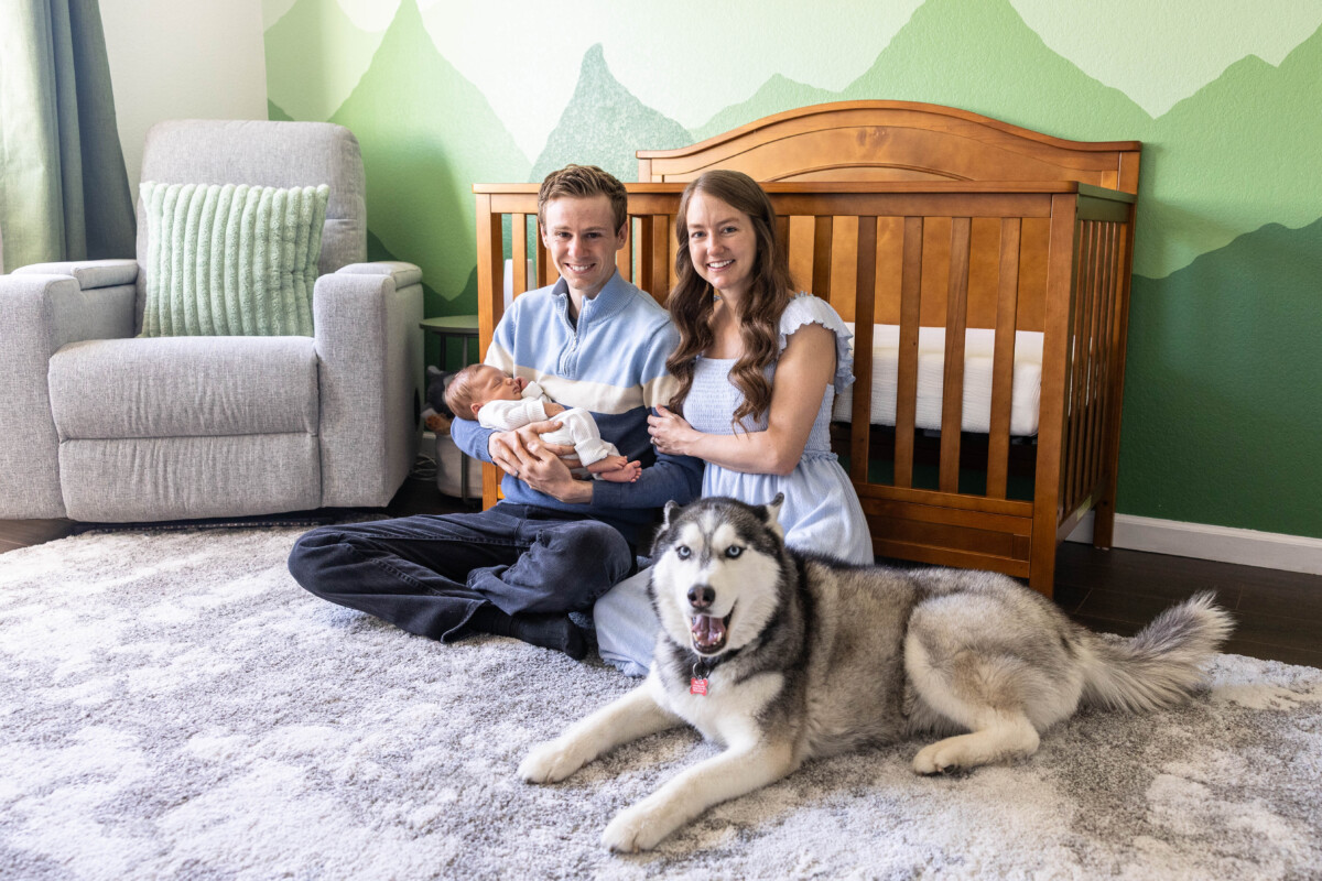 Colorado baby photographer in home for lifestyle photos with dog in nursery