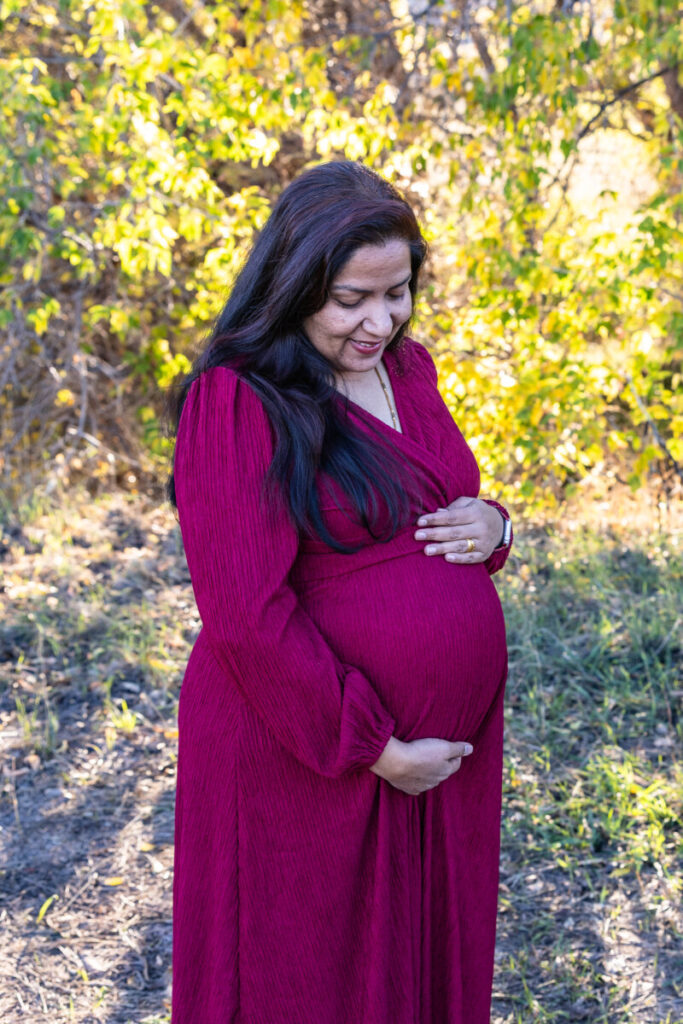 Colorado maternity photographer in Littleton with fall leaves and baby bump