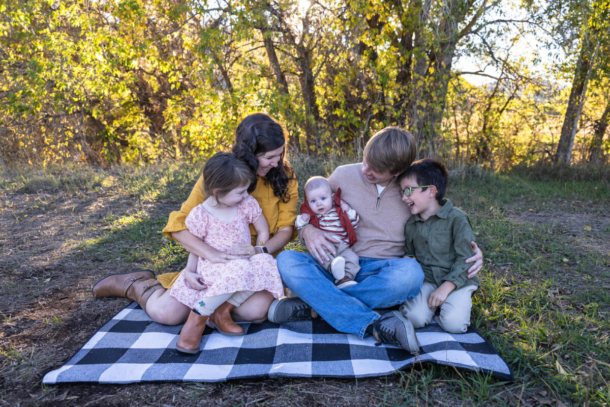 Colorado family photographer at Hildebrand Ranch with fall leaves and siblings