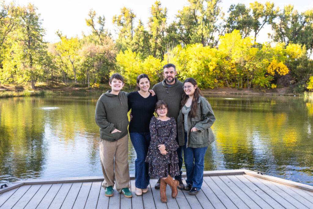 Colorado family photographer on a pond in Highlands Ranch with fall leaves