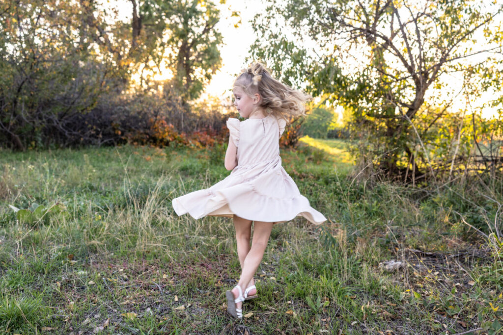 Colorado child photographer at sunset of a girl twirling