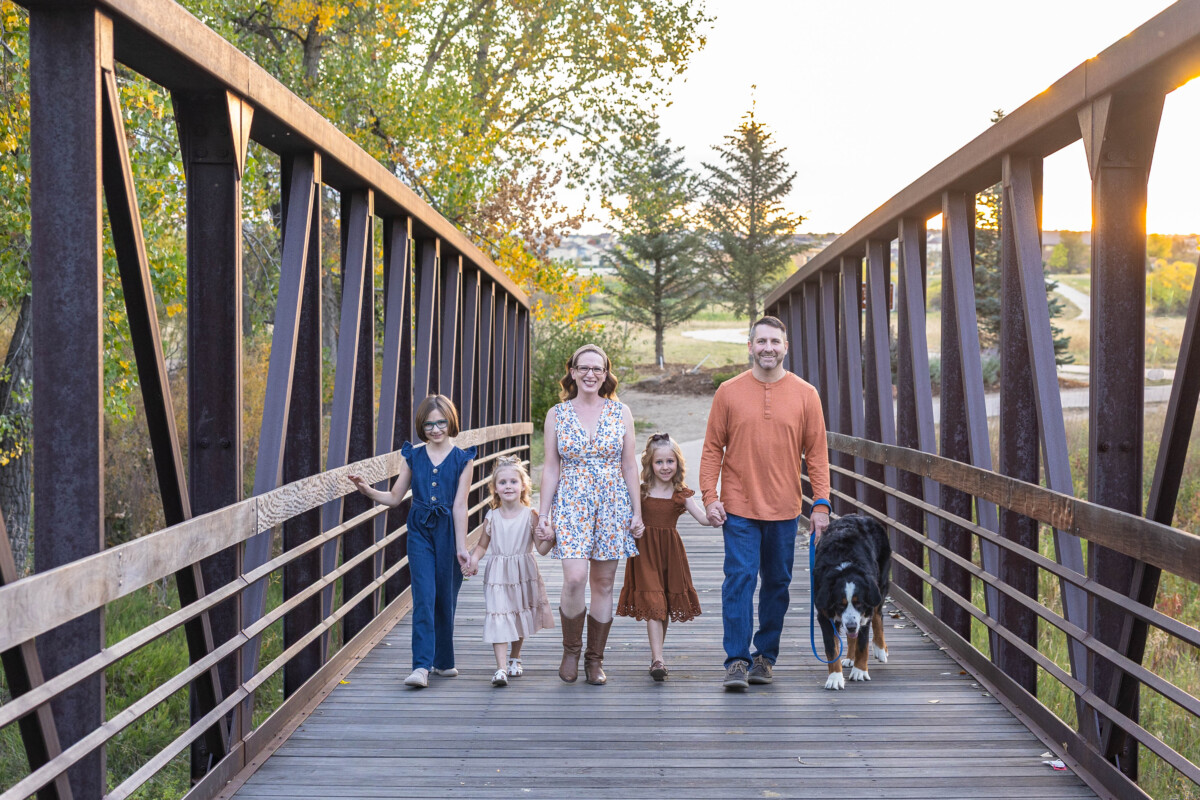 Colorado family photographer on a bridge at sunset with big dog